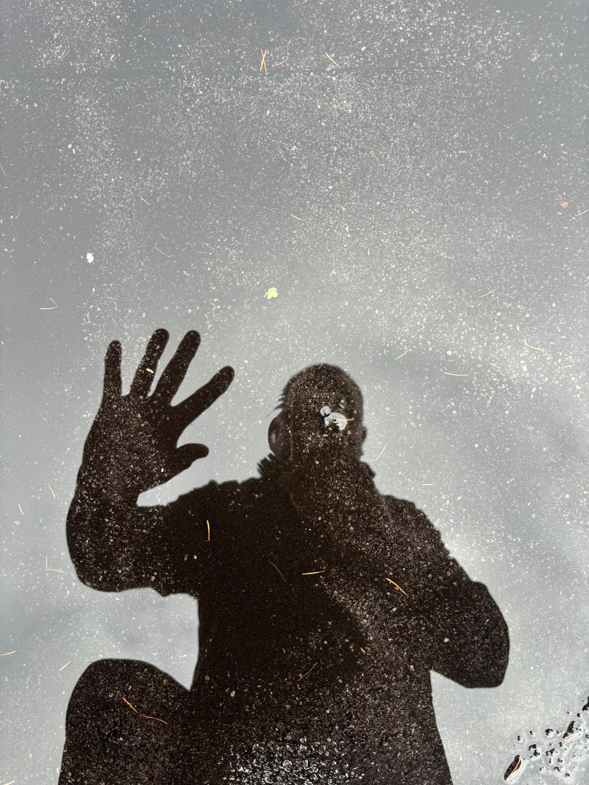 Andy's reflection waving hello in a puddle