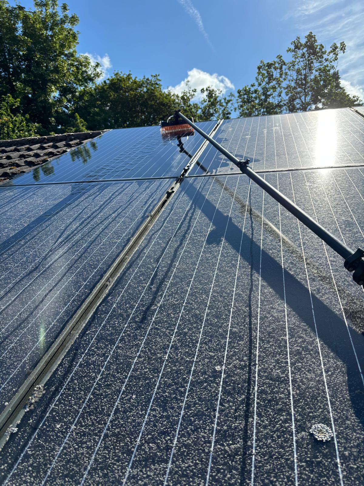 Solar panels half cleaned, showing the dusty section next to the freshly cleaned section